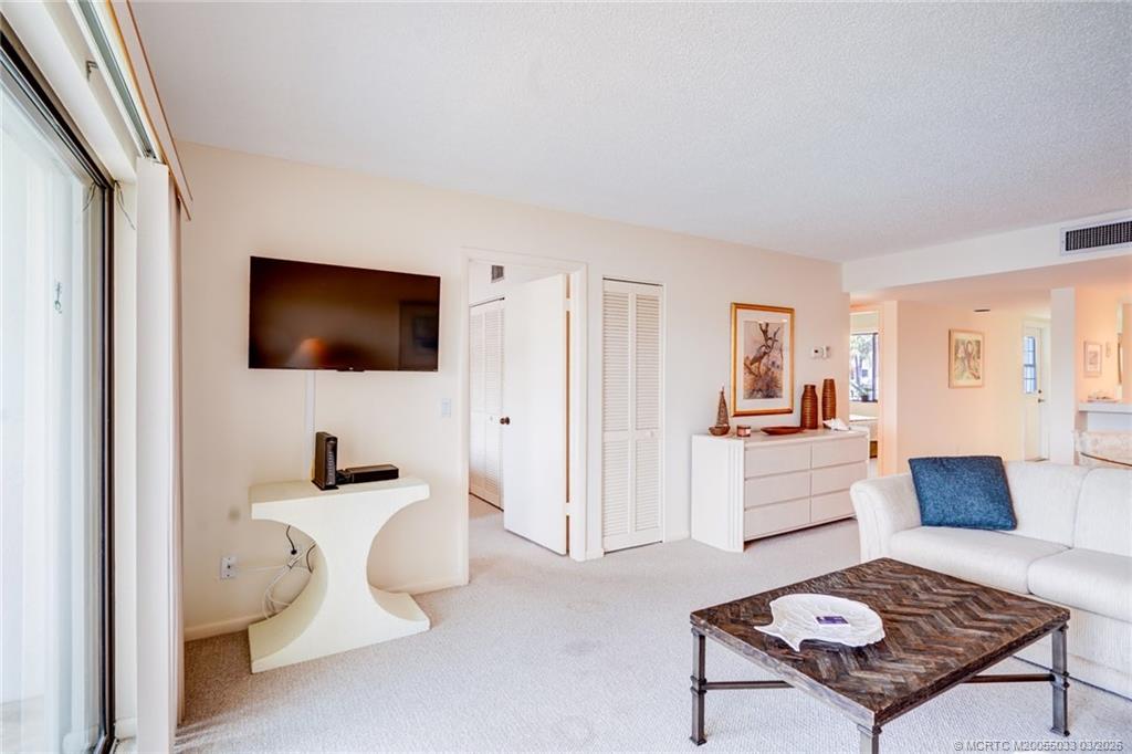 5593 Northeast Gulfstream Way Jensen Beach, FL 34957 - Photo 14 of 39 a living room with furniture and a flat screen tv