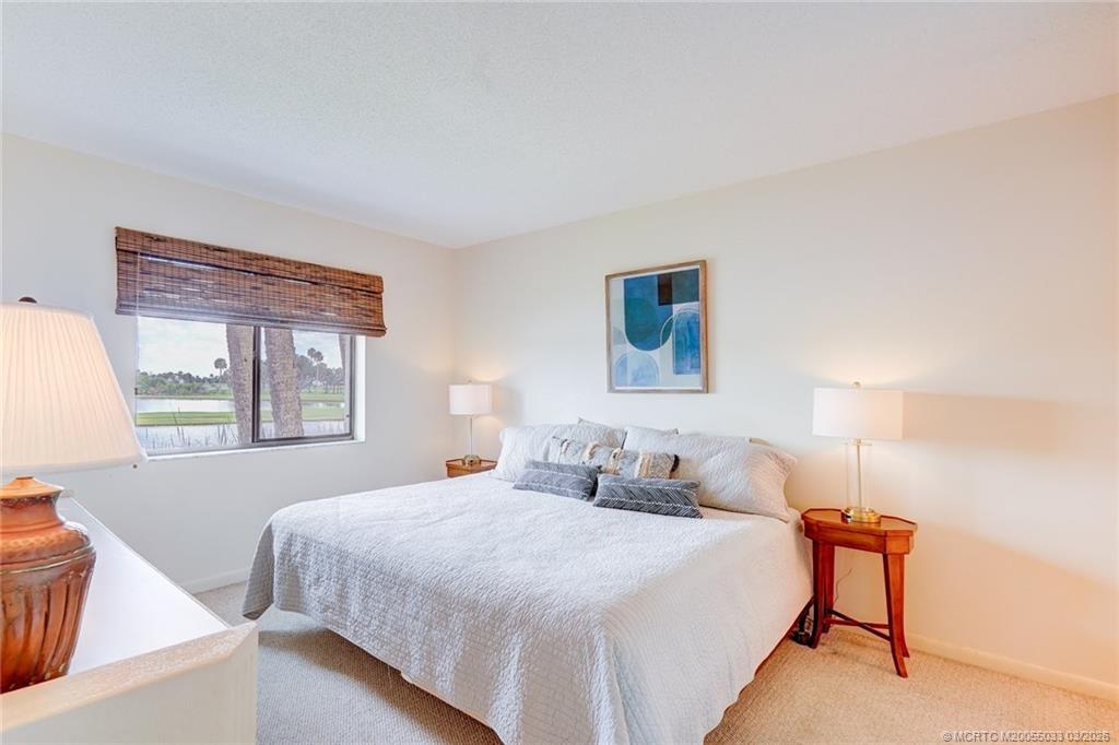 5593 Northeast Gulfstream Way Jensen Beach, FL 34957 - Photo 20 of 39 a bedroom with a bed and a window