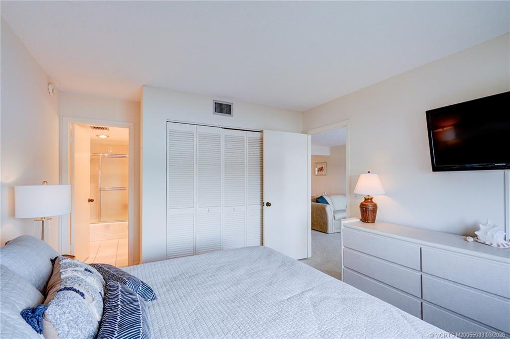 5593 Northeast Gulfstream Way Jensen Beach, FL 34957 - Photo 22 of 39 a bedroom with a bed and a flat screen tv