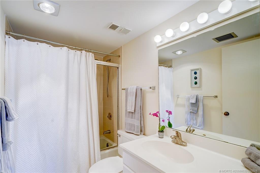 5593 Northeast Gulfstream Way Jensen Beach, FL 34957 - Photo 23 of 39 a bathroom with a sink vanity mirror and shower