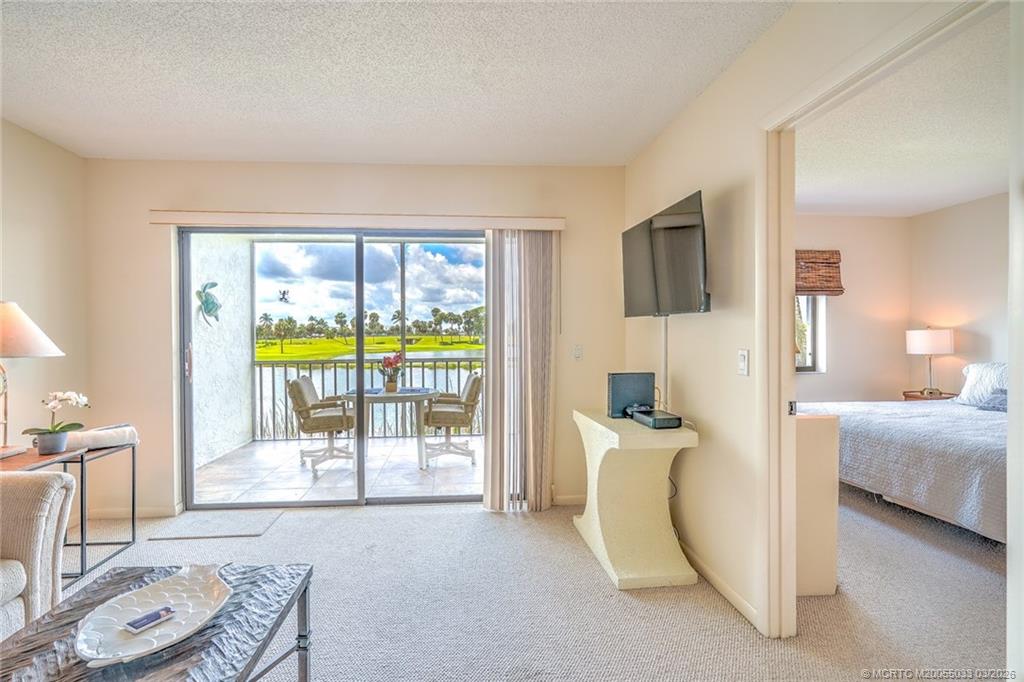 5593 Northeast Gulfstream Way Jensen Beach, FL 34957 - Photo 25 of 39 a bedroom with furniture and a flat screen tv