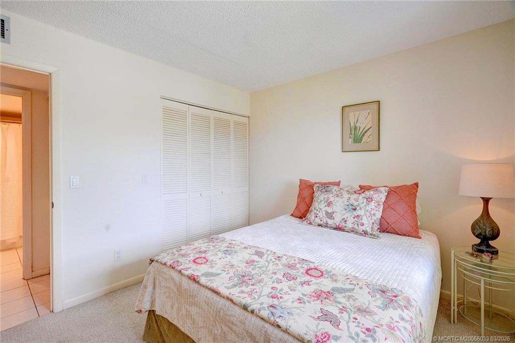 5593 Northeast Gulfstream Way Jensen Beach, FL 34957 - Photo 26 of 39 a bedroom with a bed and a table in it