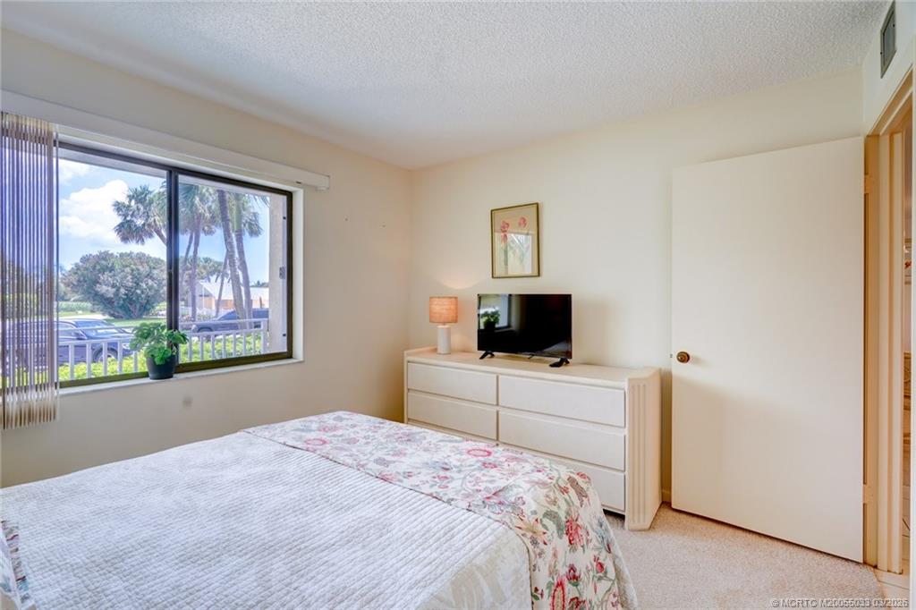 5593 Northeast Gulfstream Way Jensen Beach, FL 34957 - Photo 28 of 39 a bedroom with a bed and a flat screen tv