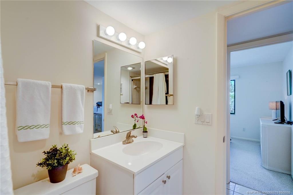 5593 Northeast Gulfstream Way Jensen Beach, FL 34957 - Photo 29 of 39 a bathroom with a sink a mirror and a shower