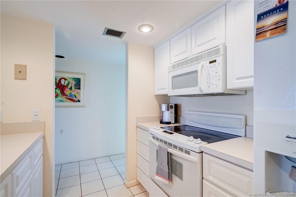 5593 Northeast Gulfstream Way Jensen Beach, FL 34957 - Photo 7 of 39 a kitchen with stainless steel appliances granite countertop a stove and a microwave