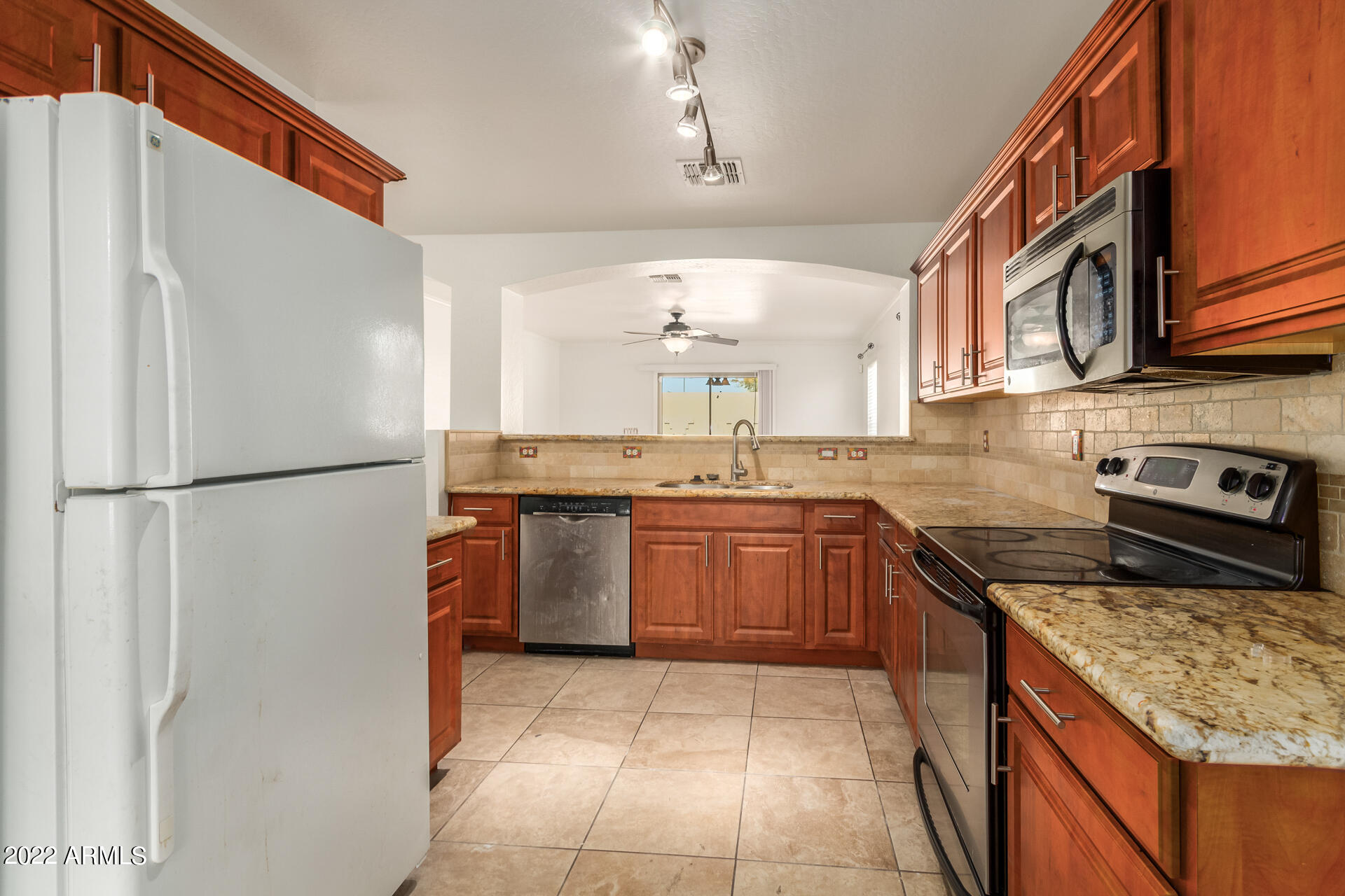 23740 West Grove Street Buckeye, AZ 85326 - Photo 3 of 23 a kitchen with stainless steel appliances granite countertop a refrigerator a sink and a stove