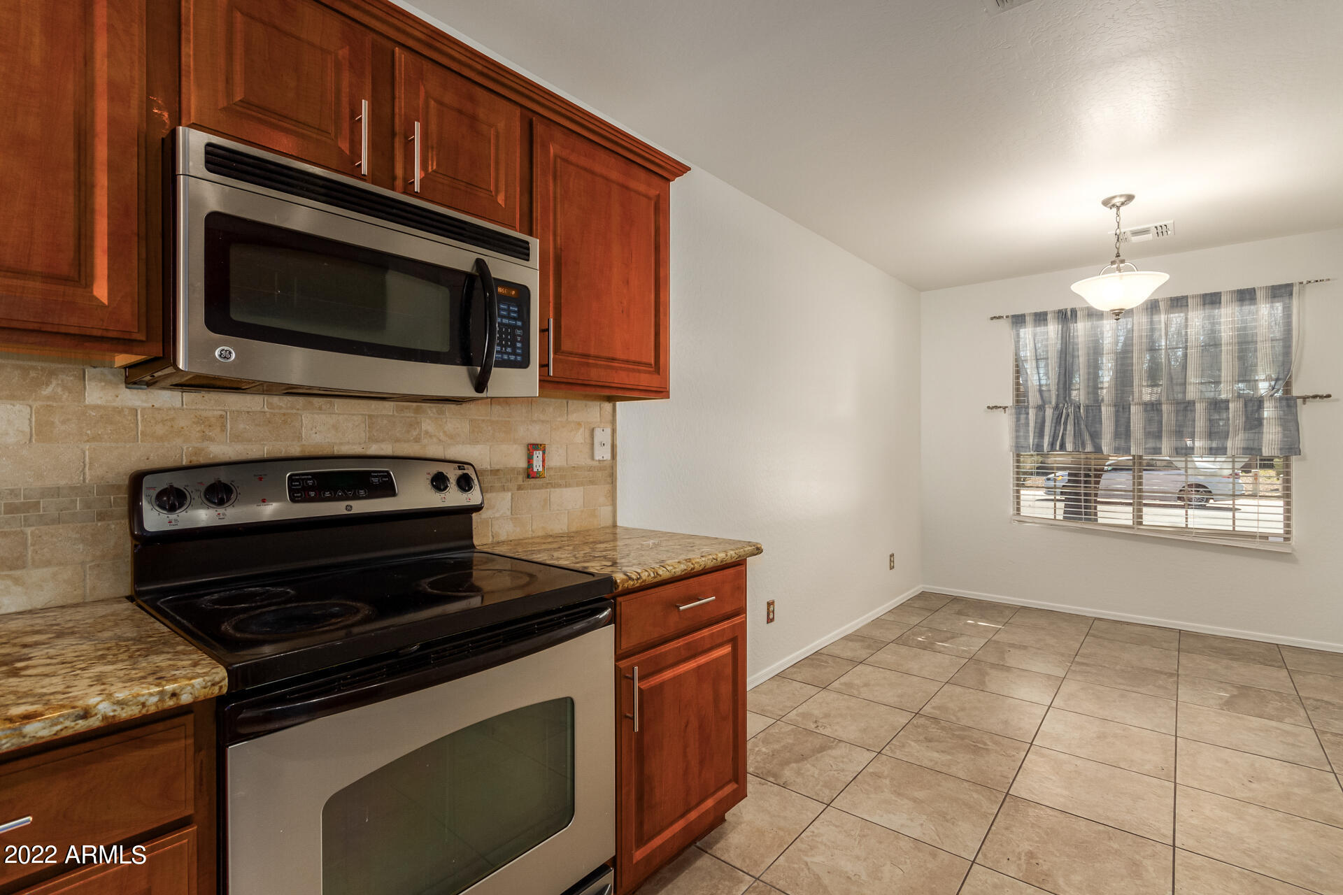 23740 West Grove Street Buckeye, AZ 85326 - Photo 6 of 23 a kitchen with stainless steel appliances granite countertop a stove microwave and sink