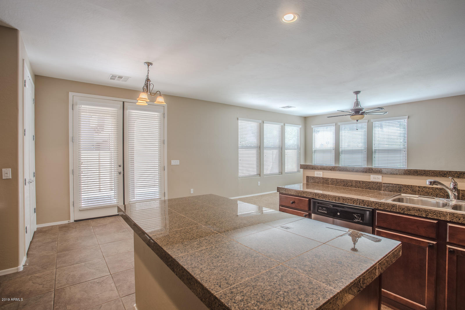 3101 South Joshua Tree Lane Gilbert, AZ 85295 - Photo 23 of 88 a living room with kitchen island a table and chandelier