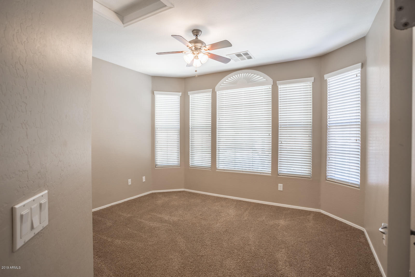 3101 South Joshua Tree Lane Gilbert, AZ 85295 - Photo 9 of 88 an empty room with windows and chandelier fan