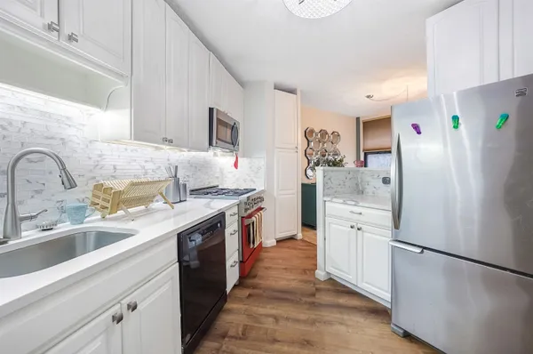 a kitchen with stainless steel appliances a stove a microwave and cabinets