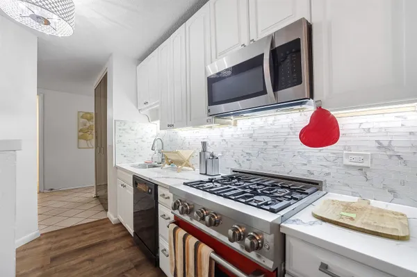 a kitchen with stainless steel appliances granite countertop a sink stove and cabinets