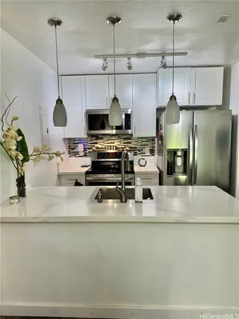 a kitchen with stainless steel appliances granite countertop a sink a stove and a refrigerator