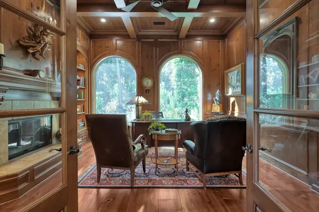 a living room with fireplace furniture and a floor to ceiling window