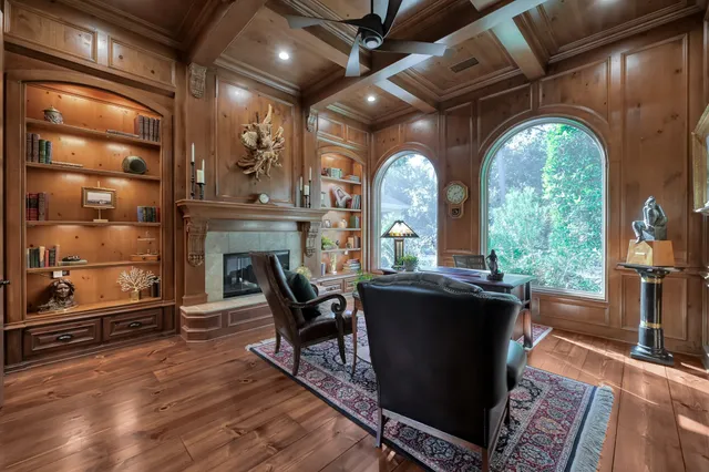 a living room with couches a fireplace with wooden floor