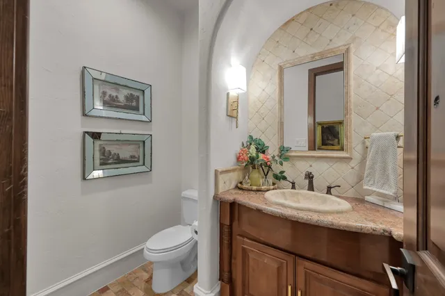 a bathroom with a toilet a sink and mirror