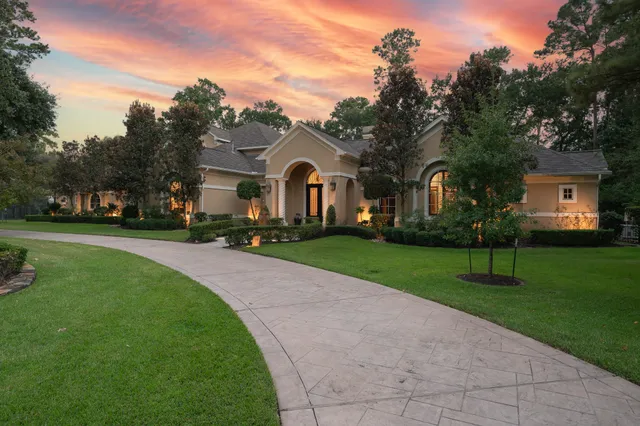 a front view of a house with a yard and trees