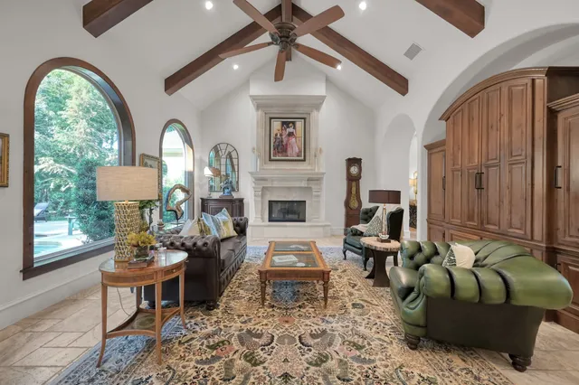 a living room with furniture a fireplace and a floor to ceiling window