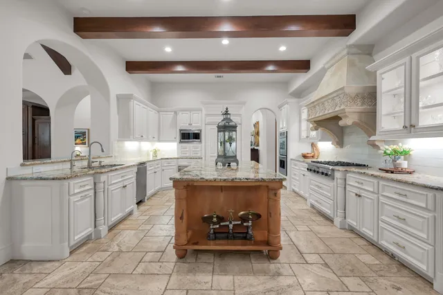 a large kitchen with kitchen island a sink stainless steel appliances and cabinets