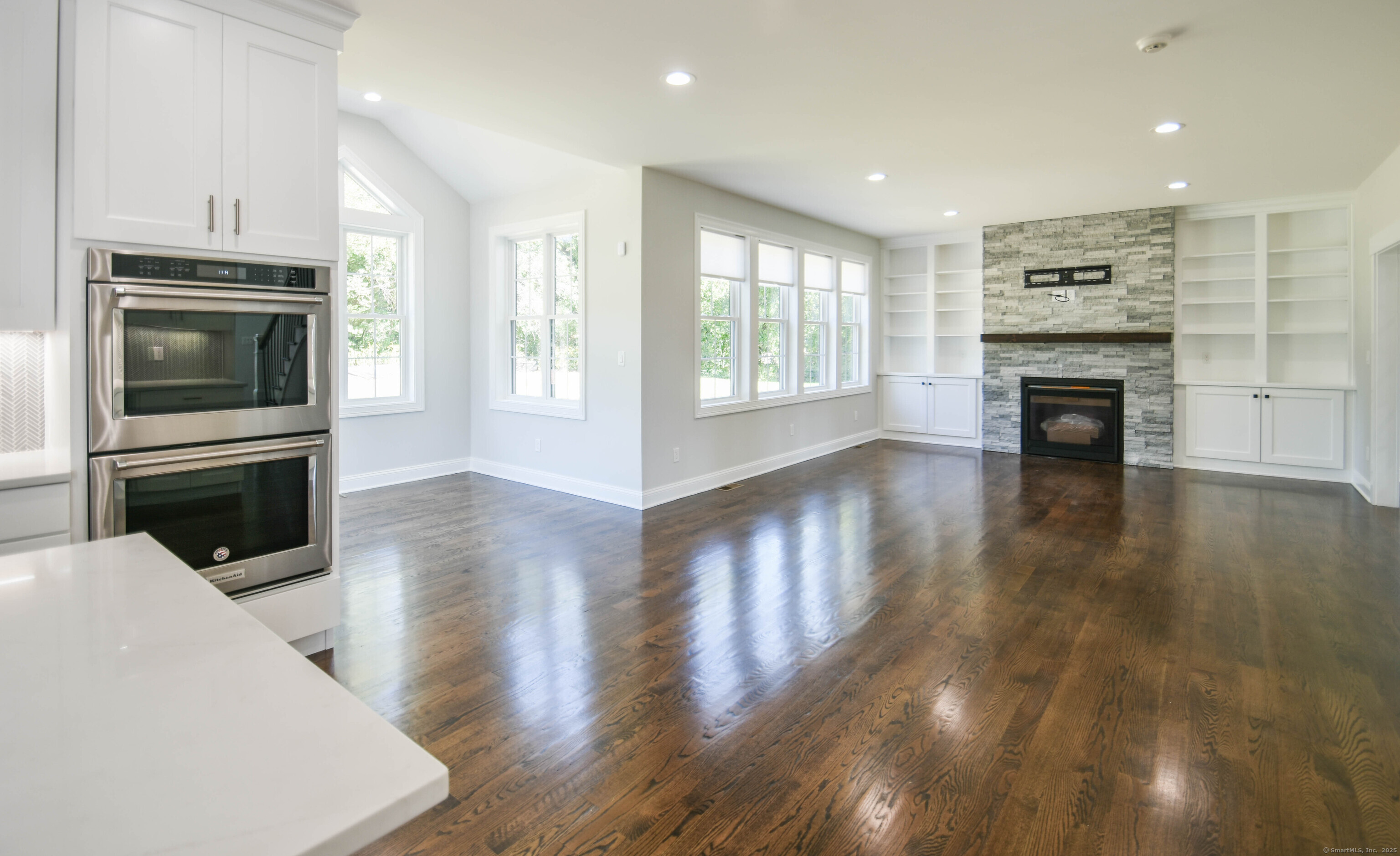 1481 Marion Road Cheshire, CT 06410 - Photo 25 of 30 a kitchen with stainless steel appliances a stove top oven a sink dishwasher and a fireplace with wooden floor