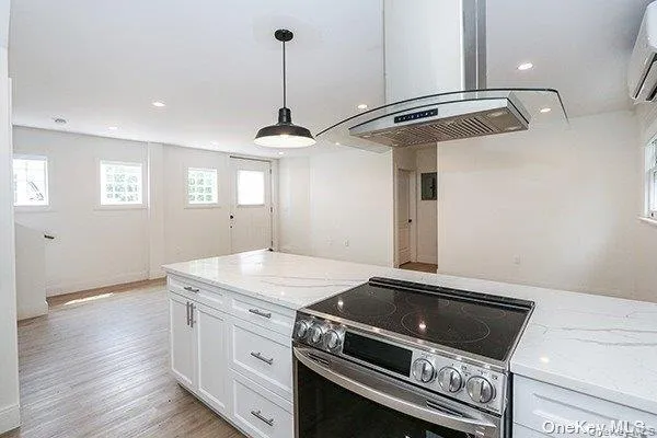 a kitchen with a stove cabinets and wooden floor