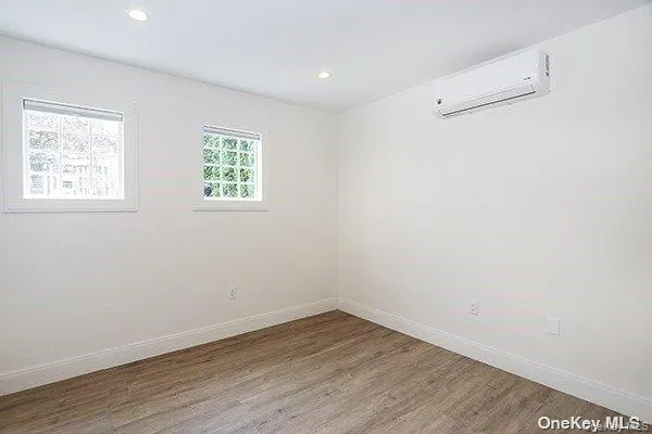 an empty room with wooden floor and window