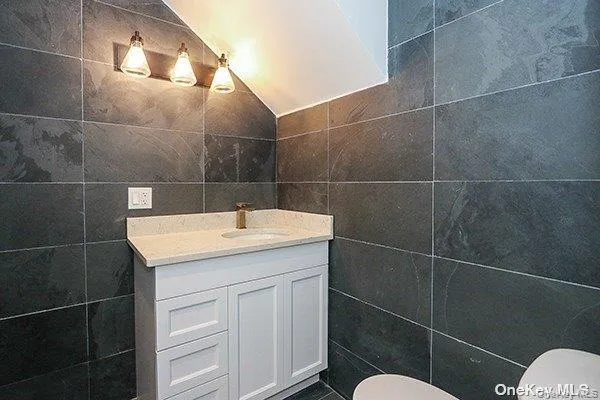 a bathroom with a sink toilet and a mirror