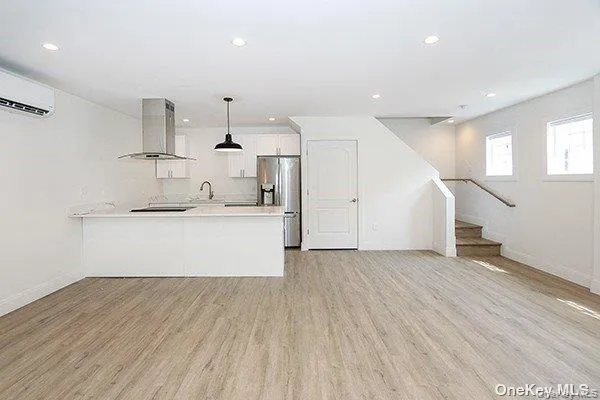 a view of a kitchen with wooden floor and staircase