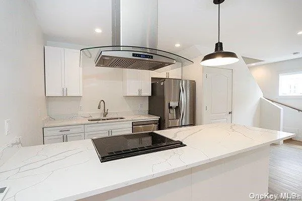 a kitchen with stainless steel appliances granite countertop a sink a stove and a refrigerator