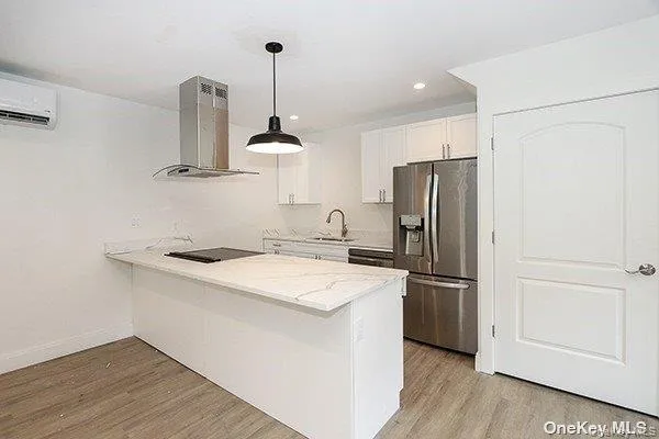 a kitchen with a refrigerator a stove and a wooden floor