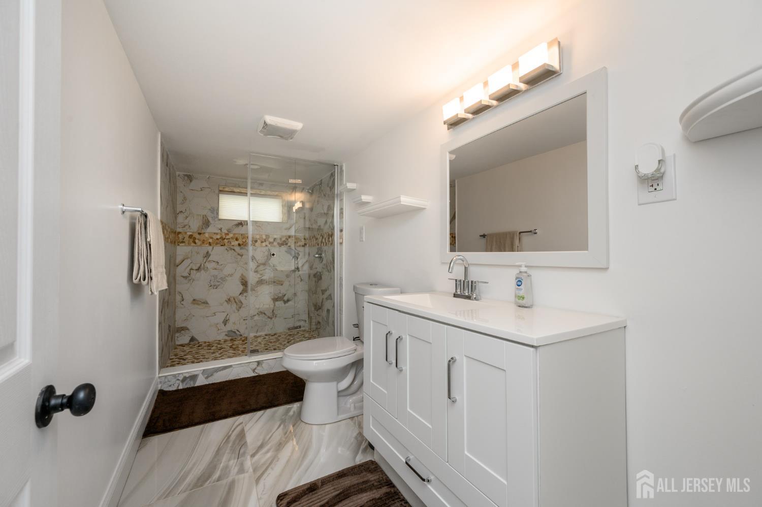 289 Indiana Street Union, NJ 07083 - Photo 37 of 45 a bathroom with a double vanity sink toilet mirror and shower