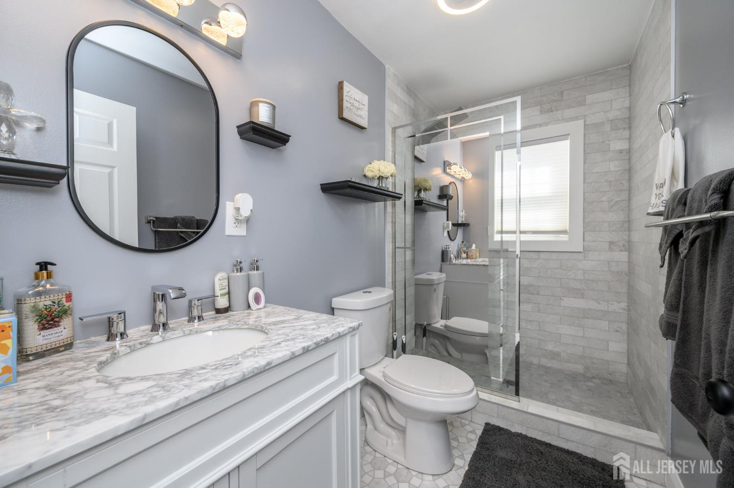 289 Indiana Street Union, NJ 07083 - Photo 8 of 45 a bathroom with a granite countertop toilet a sink and a mirror
