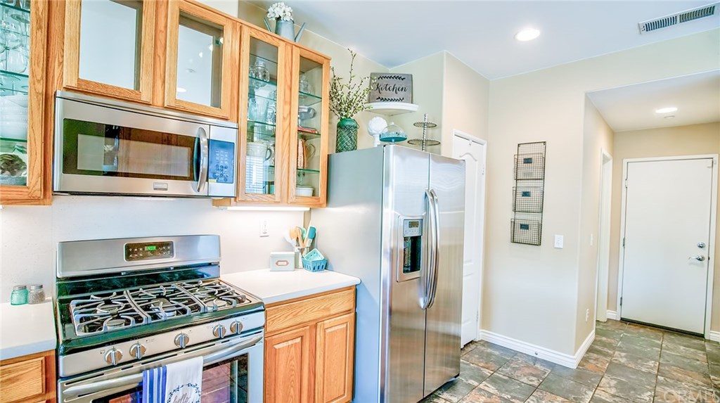 7331 Shelby Place, Unit 23 Rancho Cucamonga, CA 91739 - Photo 6 of 48 a kitchen with stainless steel appliances granite countertop a refrigerator and a stove top oven