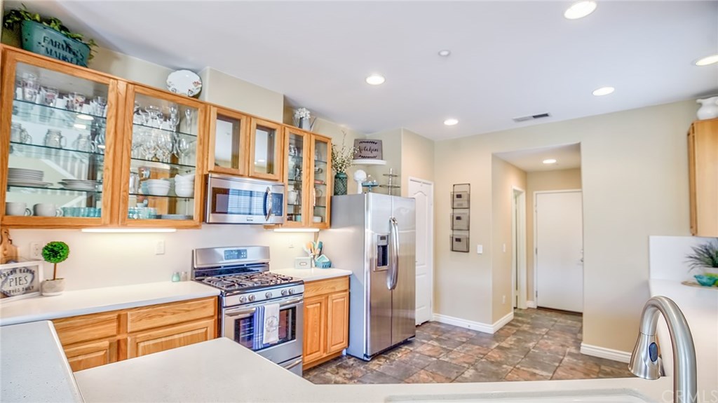 7331 Shelby Place, Unit 23 Rancho Cucamonga, CA 91739 - Photo 7 of 48 a kitchen with stainless steel appliances granite countertop a refrigerator and a stove top oven
