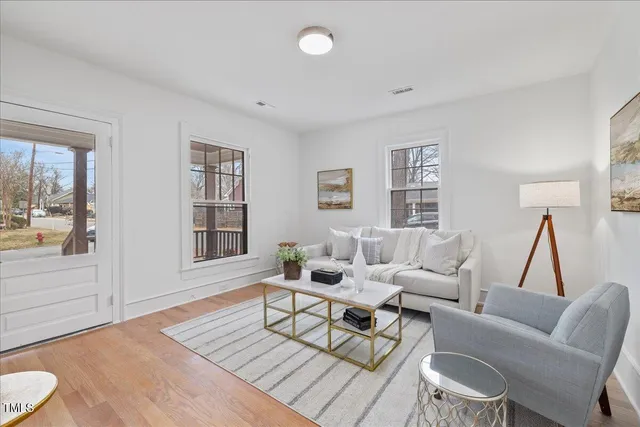 a living room with furniture and a wooden floor
