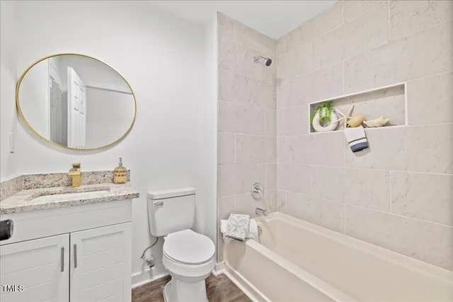 a bathroom with a granite countertop sink toilet and a mirror