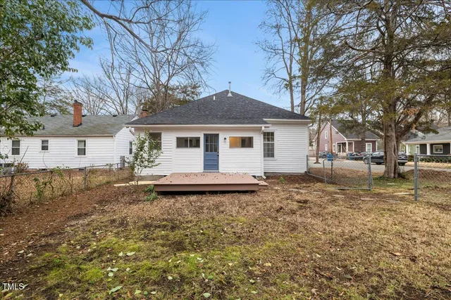 a backyard of a house with table and chairs