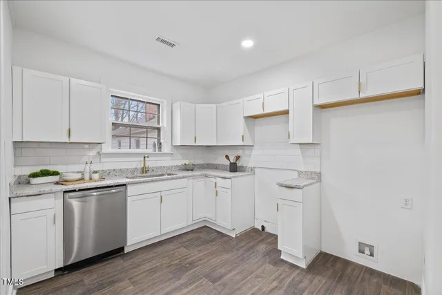 a kitchen with a sink cabinets and wooden floor
