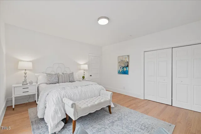 a bedroom with a bed and a lamp on the dresser