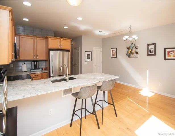 a kitchen with stainless steel appliances granite countertop a sink a stove a refrigerator cabinets and living room view