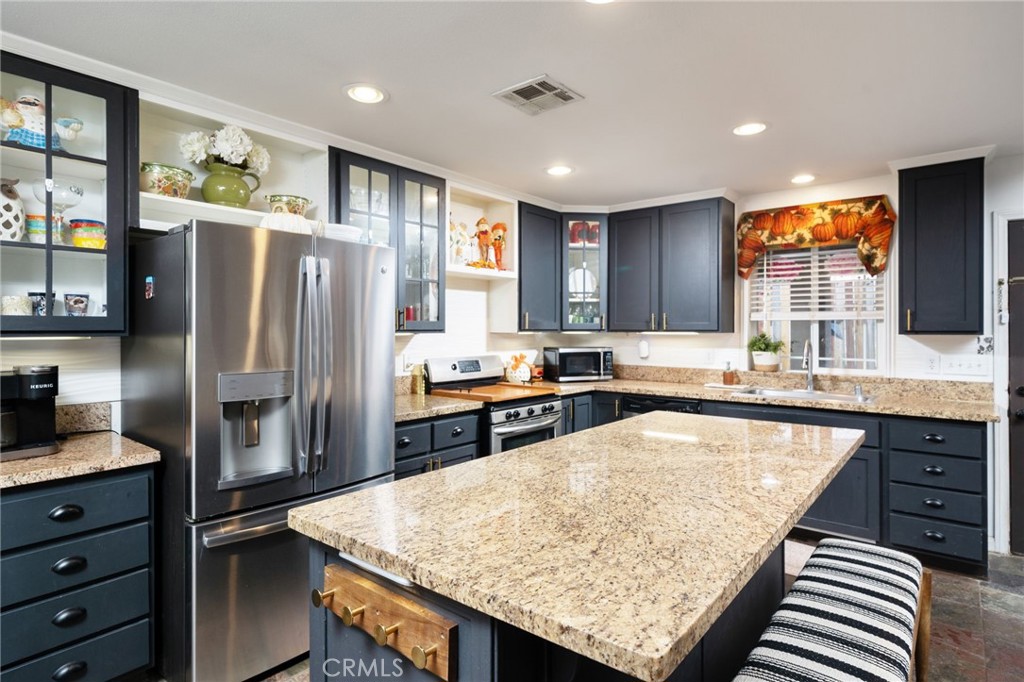 7575 Rancho Road Wrightwood, CA 92397 - Photo 13 of 32 a kitchen with stainless steel appliances granite countertop a refrigerator a sink and a stove