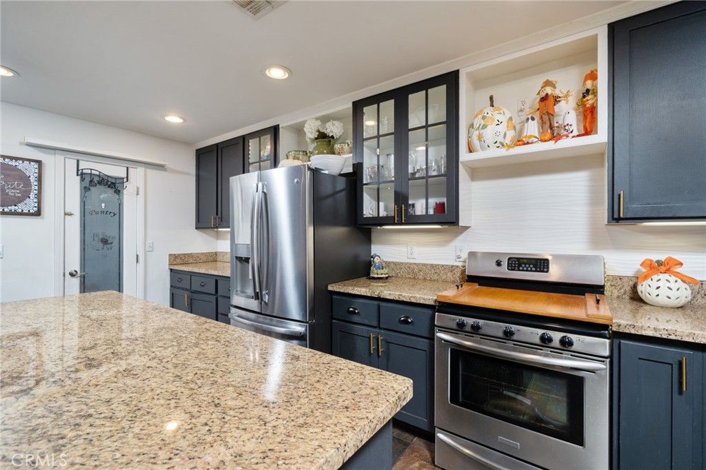 7575 Rancho Road Wrightwood, CA 92397 - Photo 14 of 32 a kitchen with stainless steel appliances a stove refrigerator sink and microwave