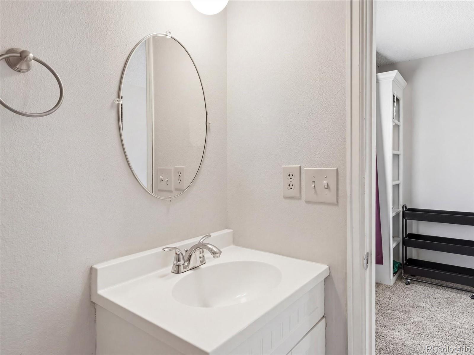 892 South Rifle Way Aurora, CO 80017 - Photo 15 of 32 a bathroom with a sink a mirror and a toilet