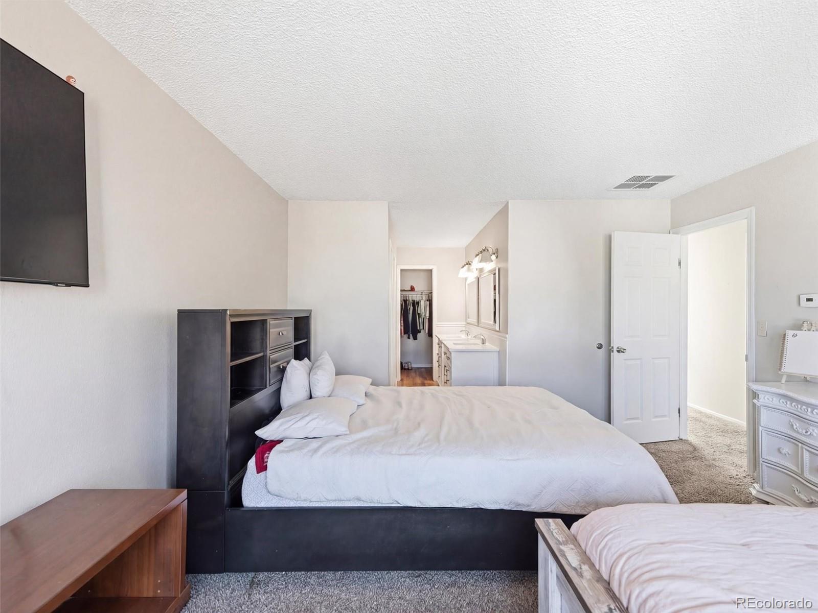 892 South Rifle Way Aurora, CO 80017 - Photo 17 of 32 a bedroom with a bed and a flat screen tv