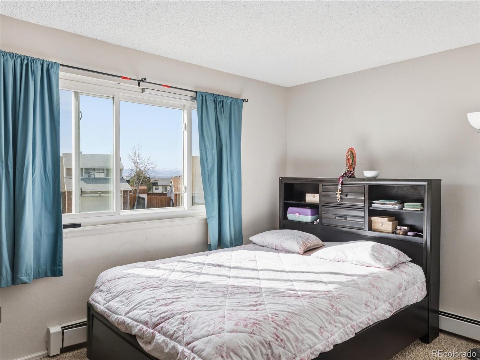 892 South Rifle Way Aurora, CO 80017 - Photo 20 of 32 a bedroom with a large bed and a window