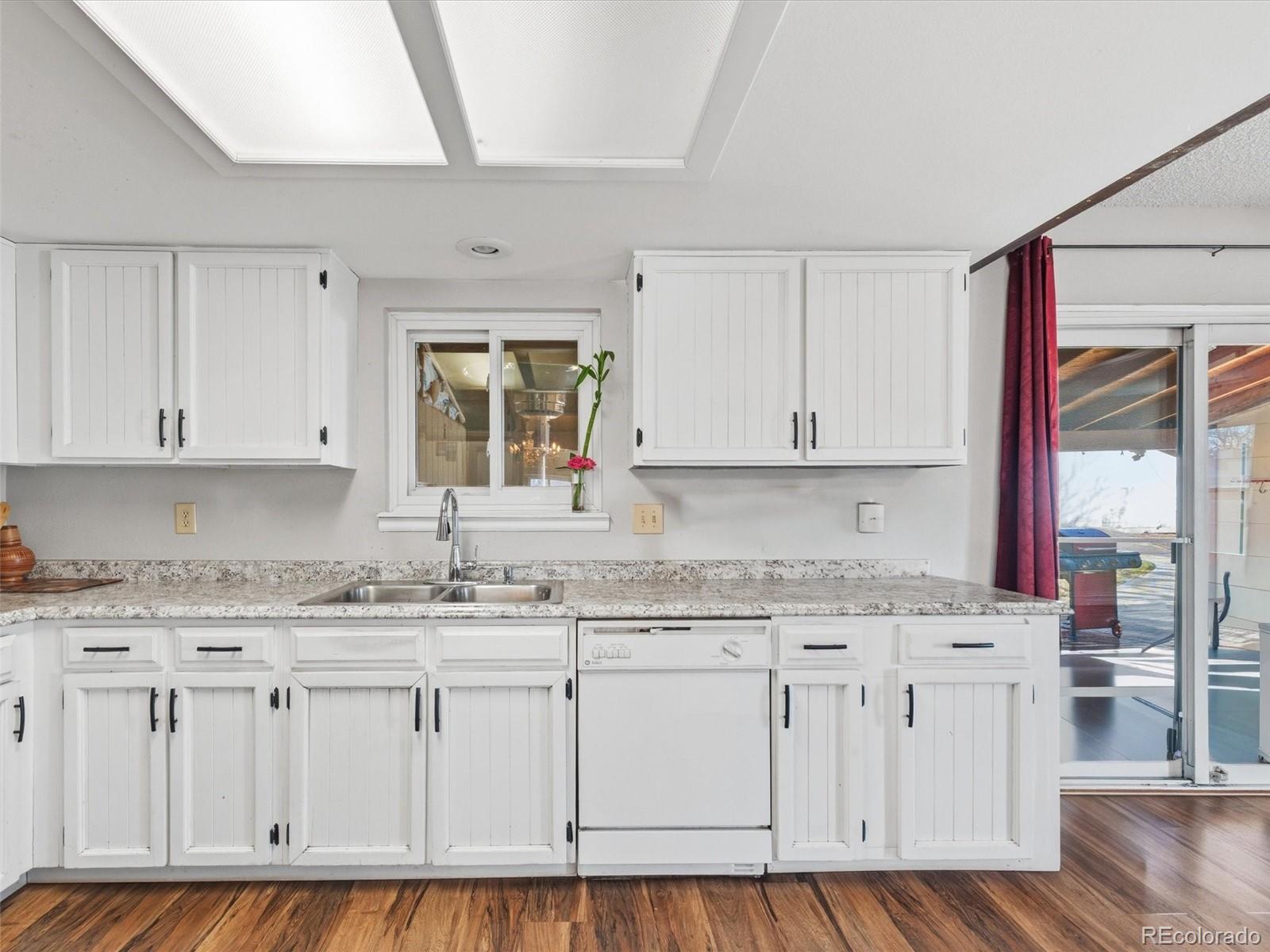 892 South Rifle Way Aurora, CO 80017 - Photo 8 of 32 a kitchen with granite countertop white cabinets and white appliances