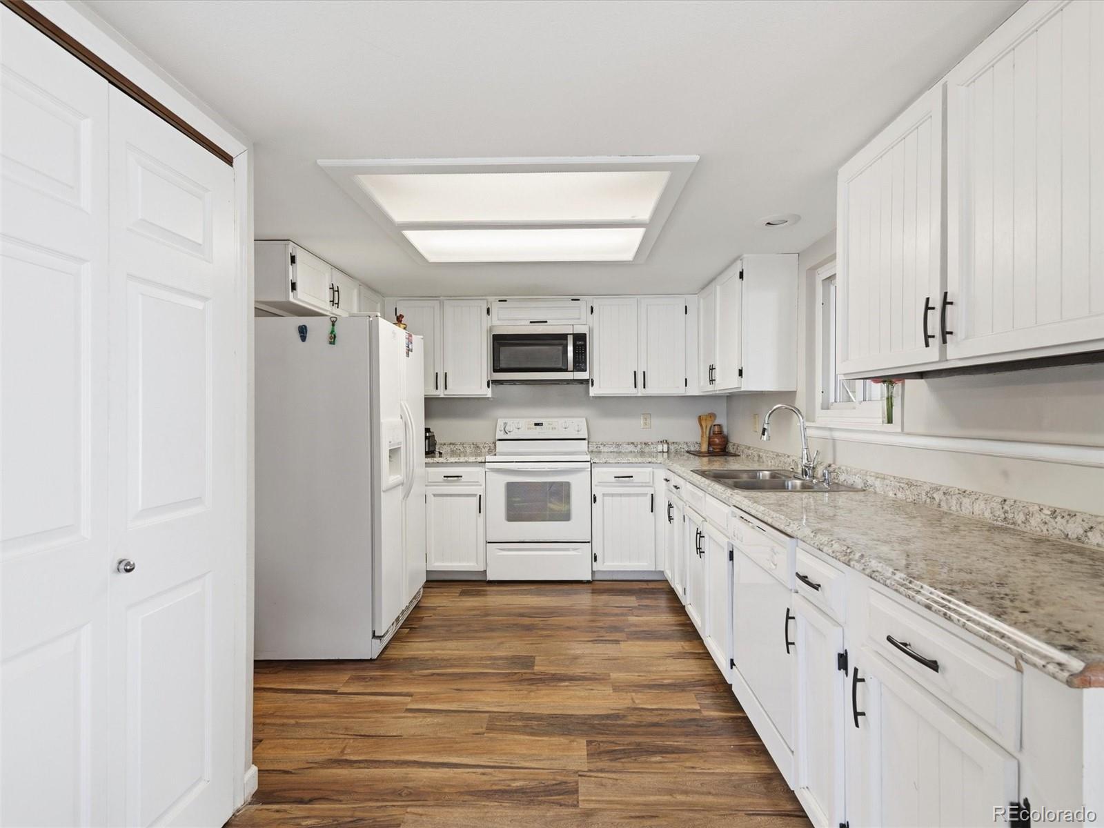892 South Rifle Way Aurora, CO 80017 - Photo 9 of 32 a large kitchen with cabinets stainless steel appliances and a window