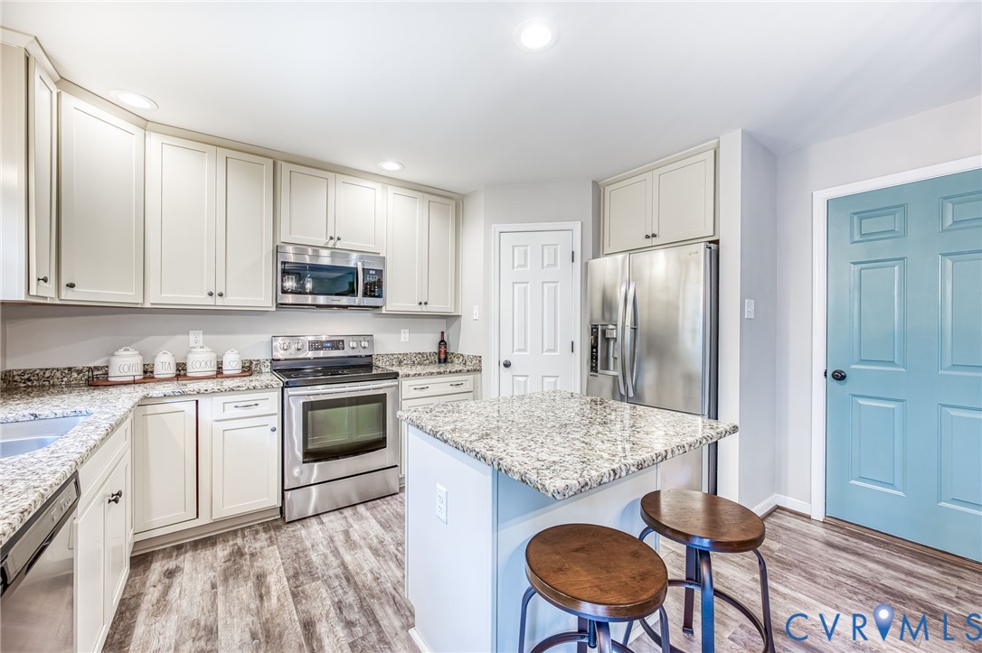 2024 Walnut Tree Place Powhatan, VA 23139 - Photo 11 of 30 a kitchen with stainless steel appliances granite countertop a stove a sink dishwasher a refrigerator with a dining table and chairs