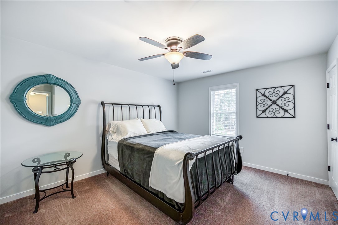 2024 Walnut Tree Place Powhatan, VA 23139 - Photo 19 of 30 a bedroom with a bed and a chandelier