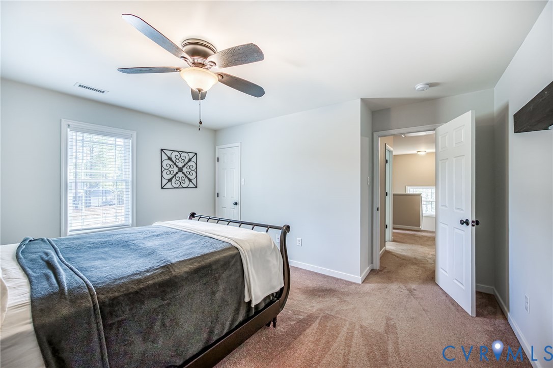 2024 Walnut Tree Place Powhatan, VA 23139 - Photo 20 of 30 a bedroom with a bed and a chandelier