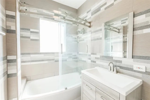 a bathroom with a tub sink shower and mirror